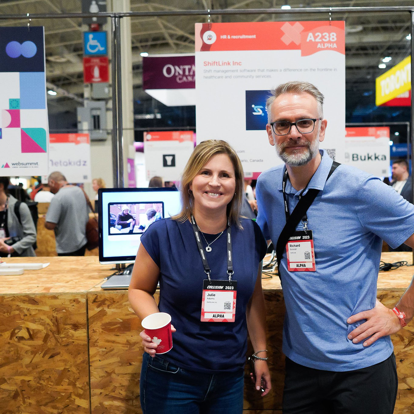 Two people smiling in front of a startup booth