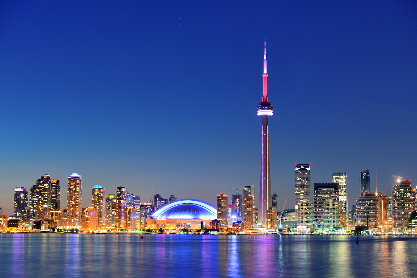 Toronto sunset over lake panorama with urban skyline.